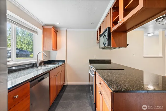 a kitchen with stainless steel appliances granite countertop a sink and a stove