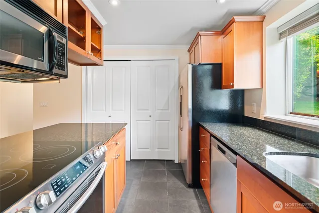 a kitchen with stainless steel appliances granite countertop a sink and a stove