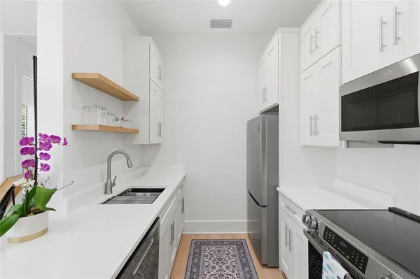 a kitchen that has a sink and a stove in it