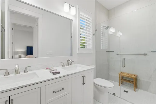 a bathroom with a sink vanity granite toilet and a mirror