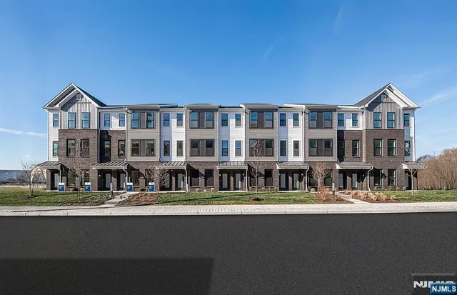 a front view of a building with a fountain and a yard