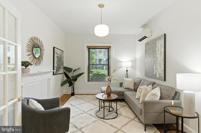 a living room with furniture a lamp and a window