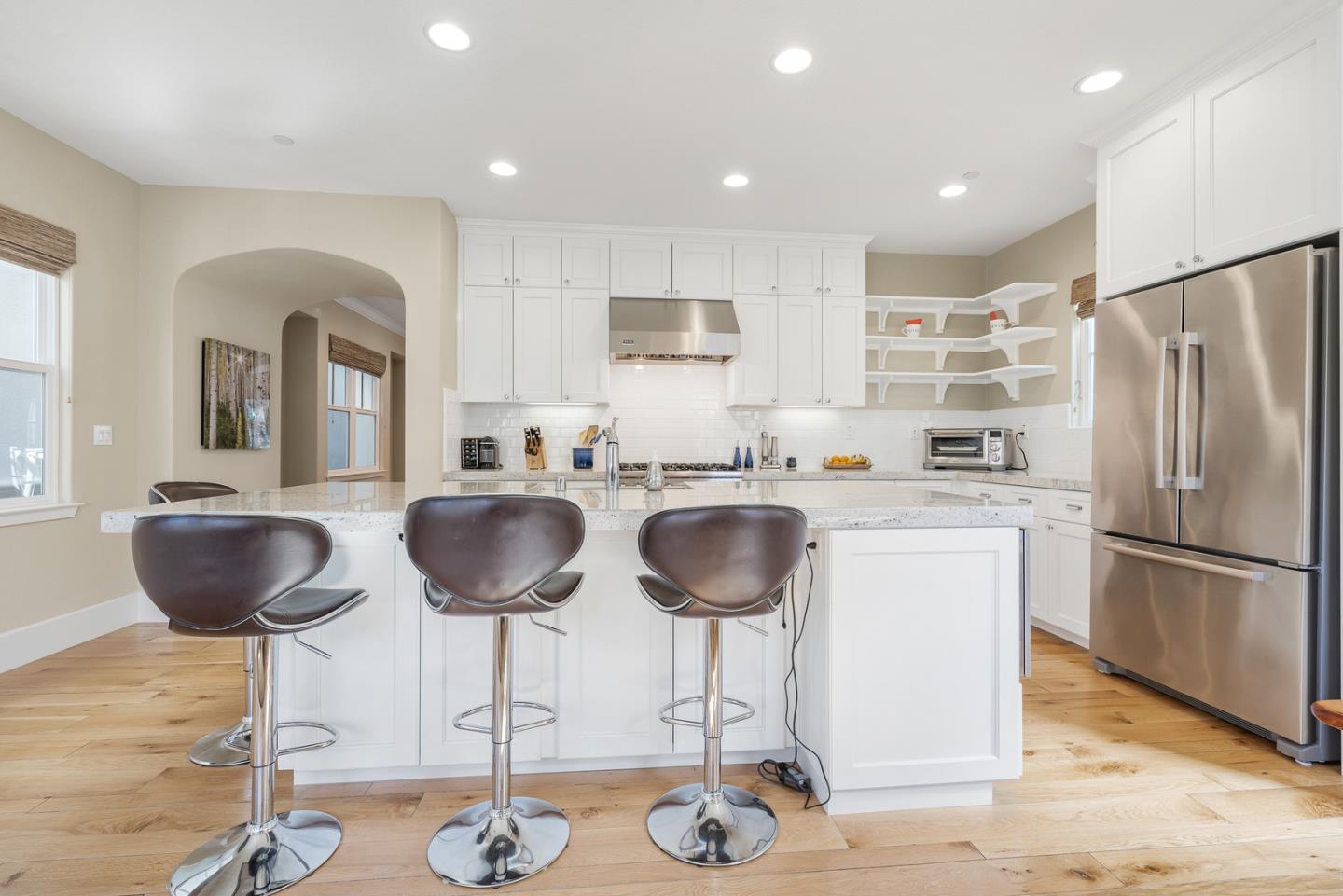 107 Savannah Loop Mountain View, CA 94043 - Photo 5 of 29 a kitchen with granite countertop a refrigerator a stove a kitchen island with chairs and wooden floor