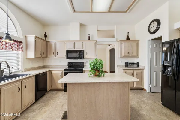 a kitchen with kitchen island white cabinets and refrigerator