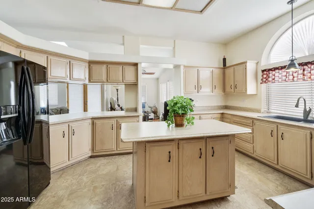 a kitchen with white cabinets and refrigerator