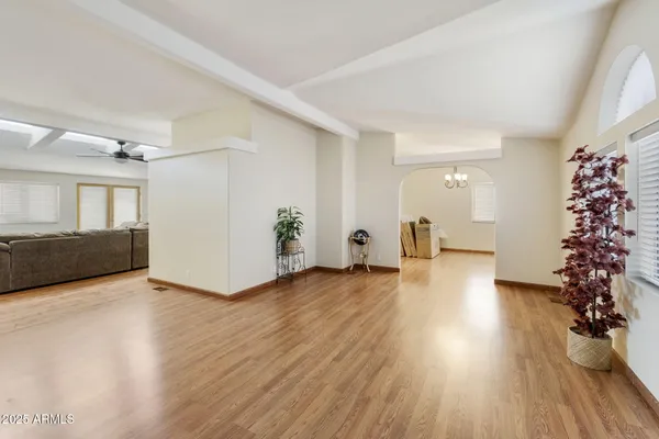 a view of an empty room with potted plants and wooden floor