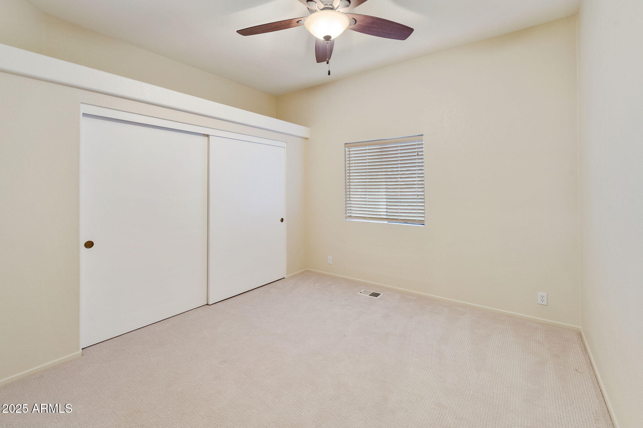 3700 South Tomahawk Road, Unit 83 Apache Junction, AZ 85119 - Photo 27 of 31 an empty room with a chandelier fan and windows