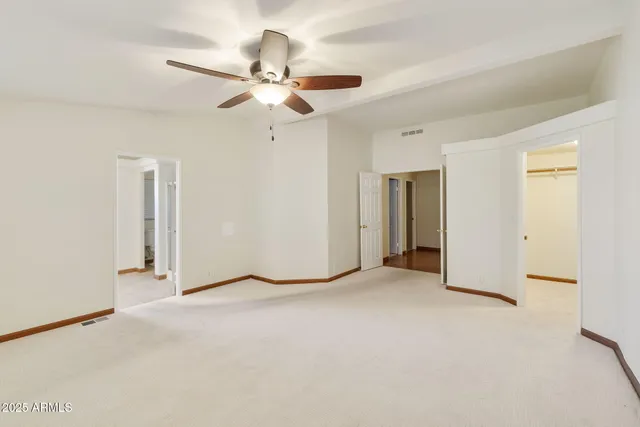 an empty room with a ceiling fan and a window