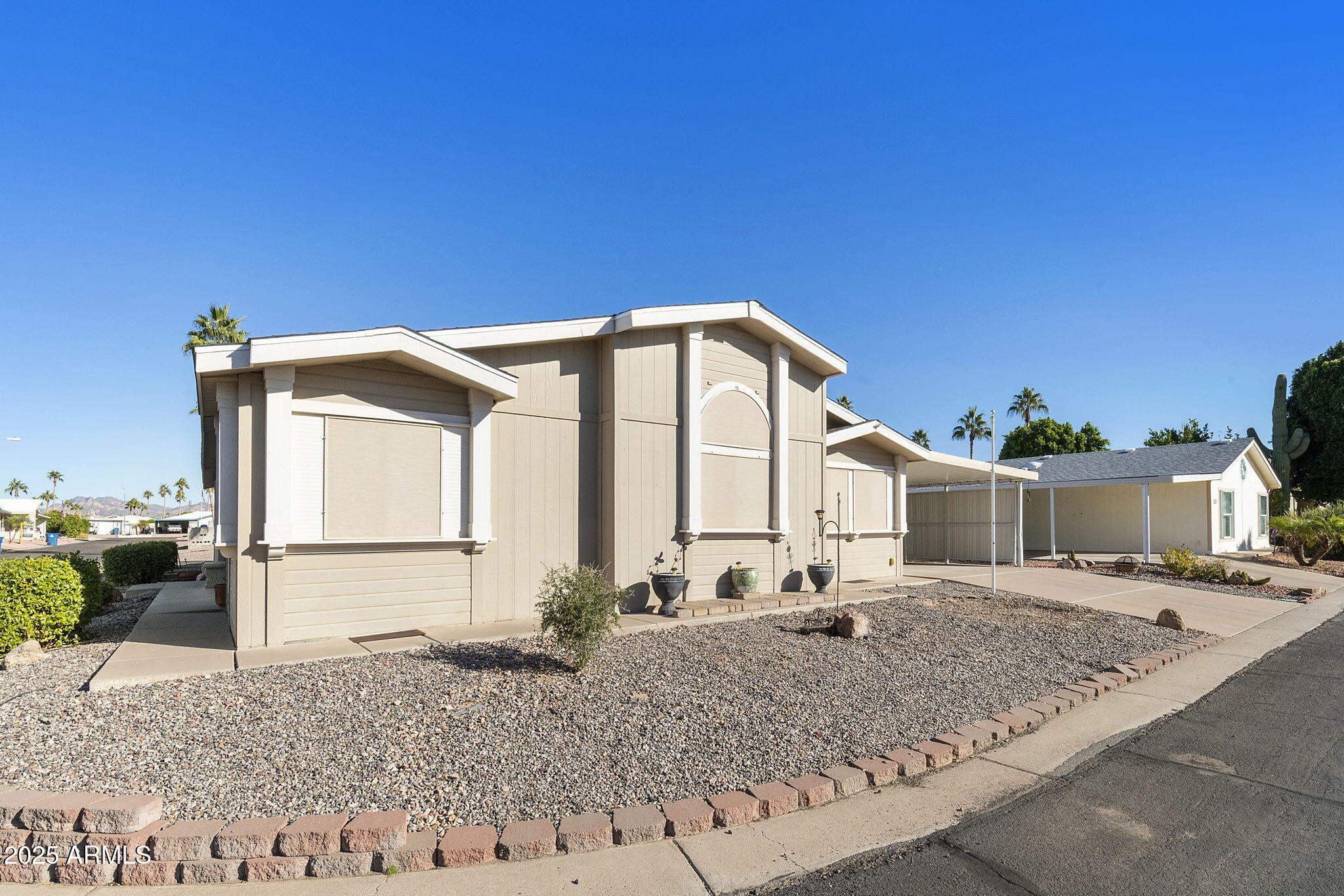 3700 South Tomahawk Road, Unit 83 Apache Junction, AZ 85119 - Photo 3 of 31 a backyard of a house with barbeque oven table and chairs