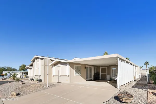 a view of a white house with a big yard and large trees