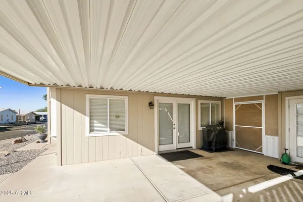 a view of a livingroom with wooden floor and kitchen space