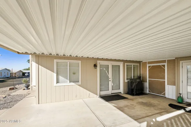 a view of a livingroom with wooden floor and kitchen space
