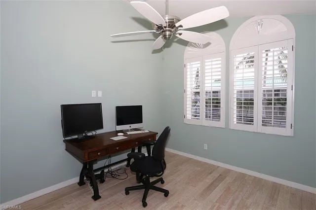 a view of a workspace with furniture and a window