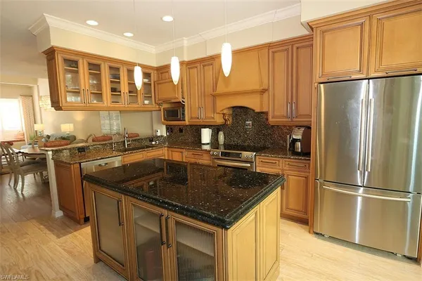 a kitchen with kitchen island granite countertop a sink and refrigerator