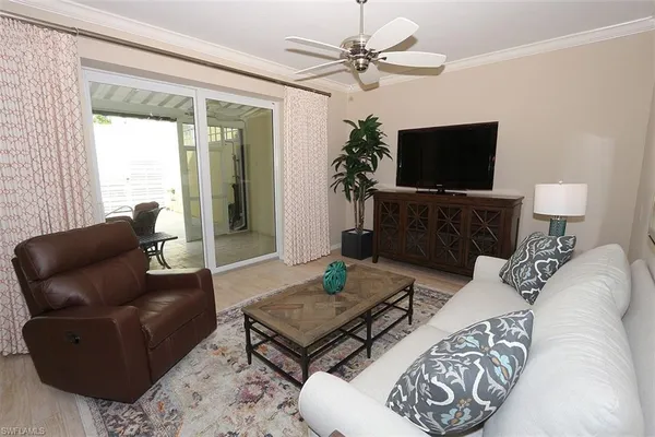 a living room with furniture a flat screen tv and a large window