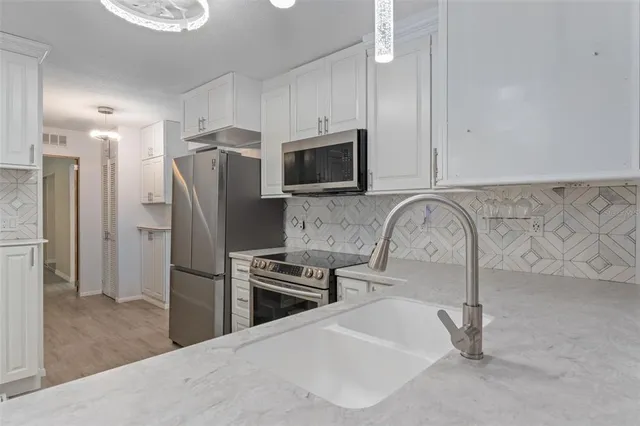 a kitchen with stainless steel appliances a refrigerator microwave and stove top oven