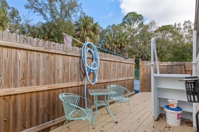 a view of a chairs on the deck in backyard