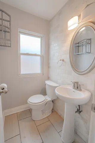 a bathroom with a toilet sink and mirror