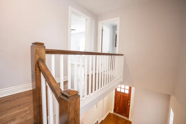 a view of staircase with railing and white walls