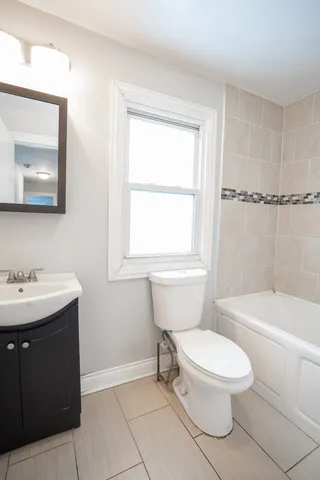 a white toilet sitting next to a bathroom sink