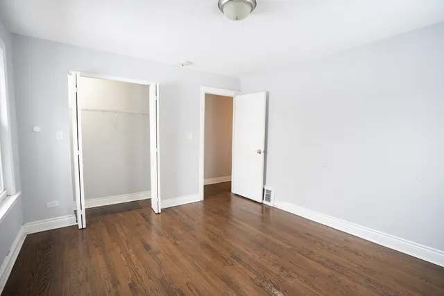 an empty room with wooden floor and closet