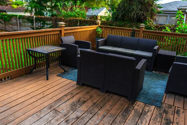 a balcony with wooden floor and outdoor seating