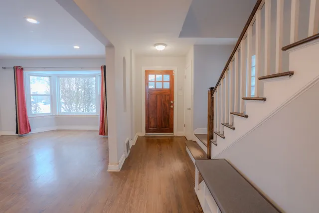 a view of an entryway with wooden floor and stairs