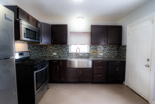 a kitchen with stainless steel appliances granite countertop a stove microwave and refrigerator