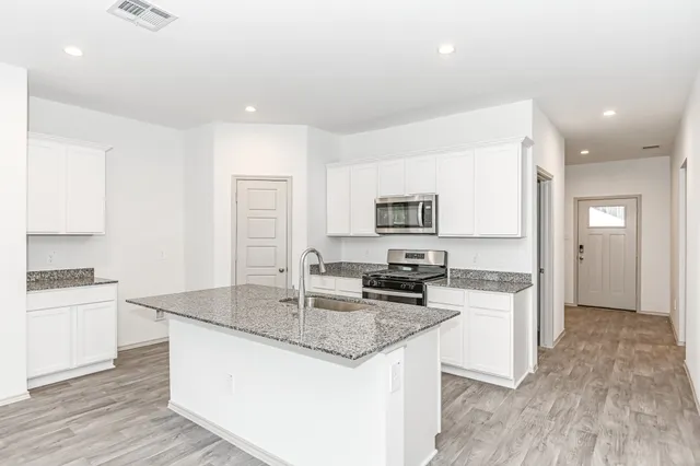 a kitchen with granite countertop a stove and a sink