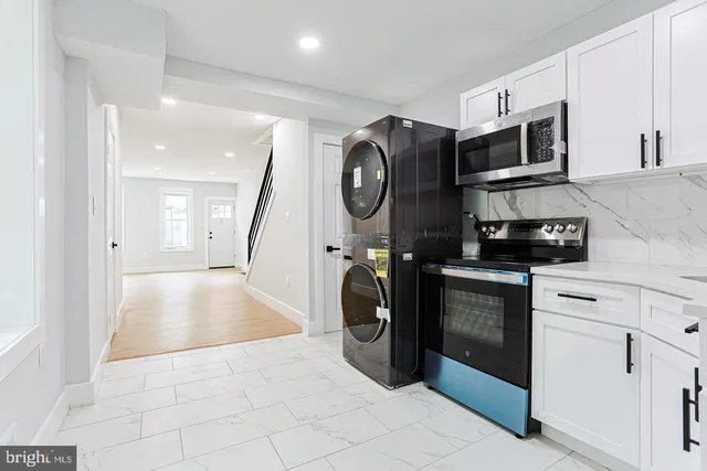 a view of a kitchen with a sink and a washer dryer