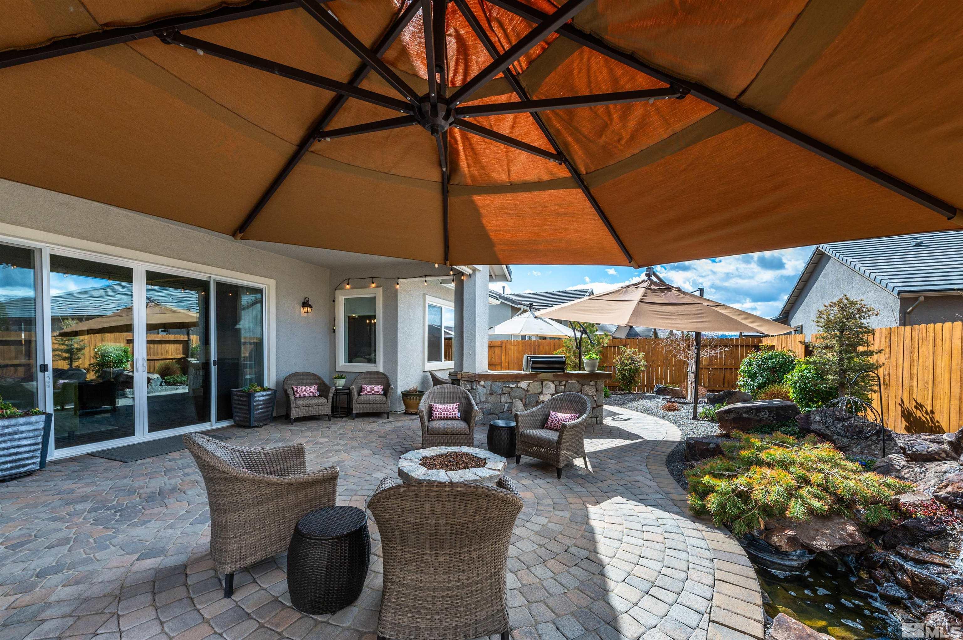 9805 Shadowless Trail Reno, NV 89521 - Photo 22 of 33 a patio with patio a table and chairs under an umbrella