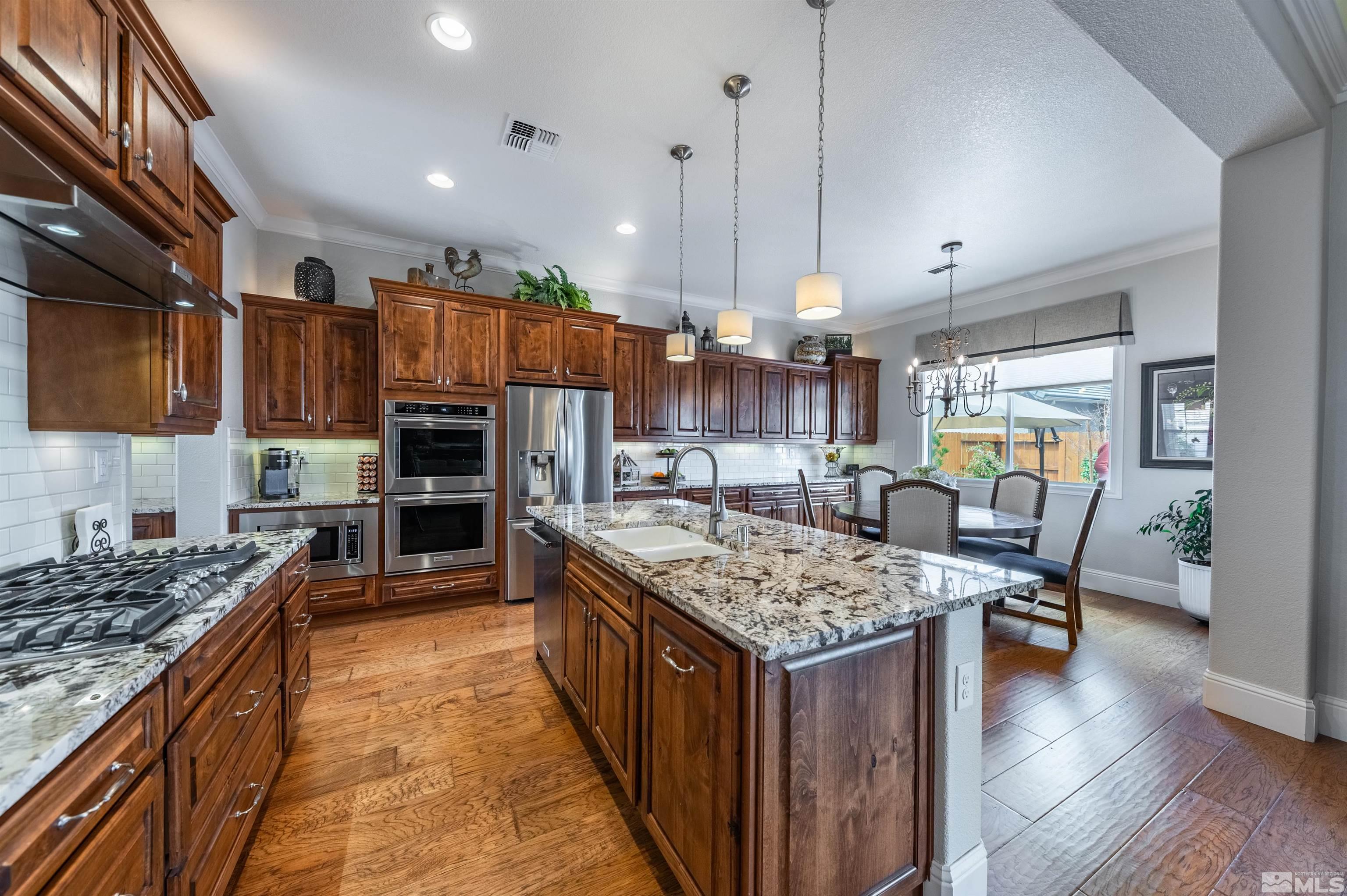 9805 Shadowless Trail Reno, NV 89521 - Photo 7 of 33 a kitchen with a counter top space a sink appliances and cabinets