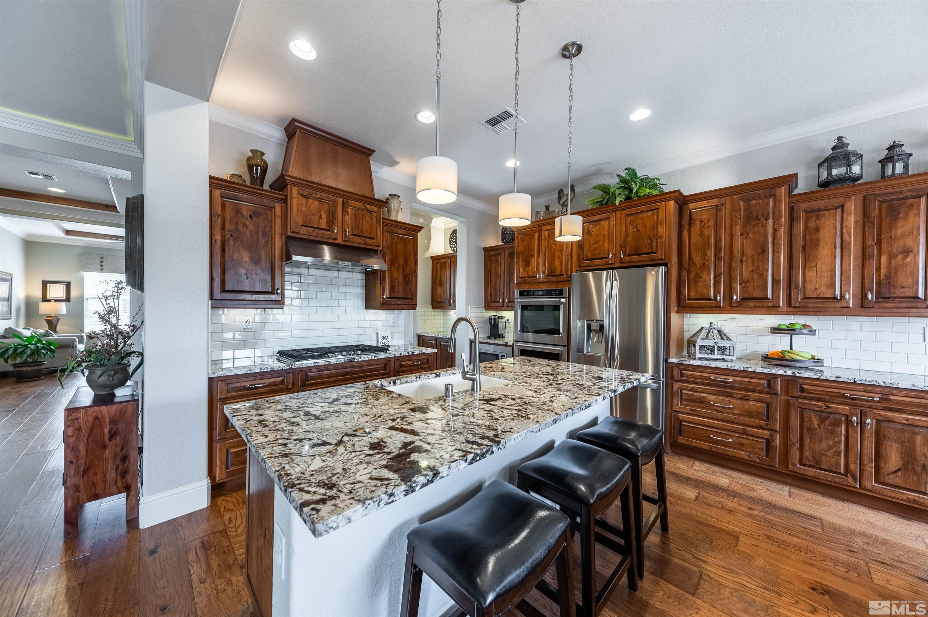 9805 Shadowless Trail Reno, NV 89521 - Photo 8 of 33 a kitchen with stainless steel appliances granite countertop table chairs sink and wooden cabinets