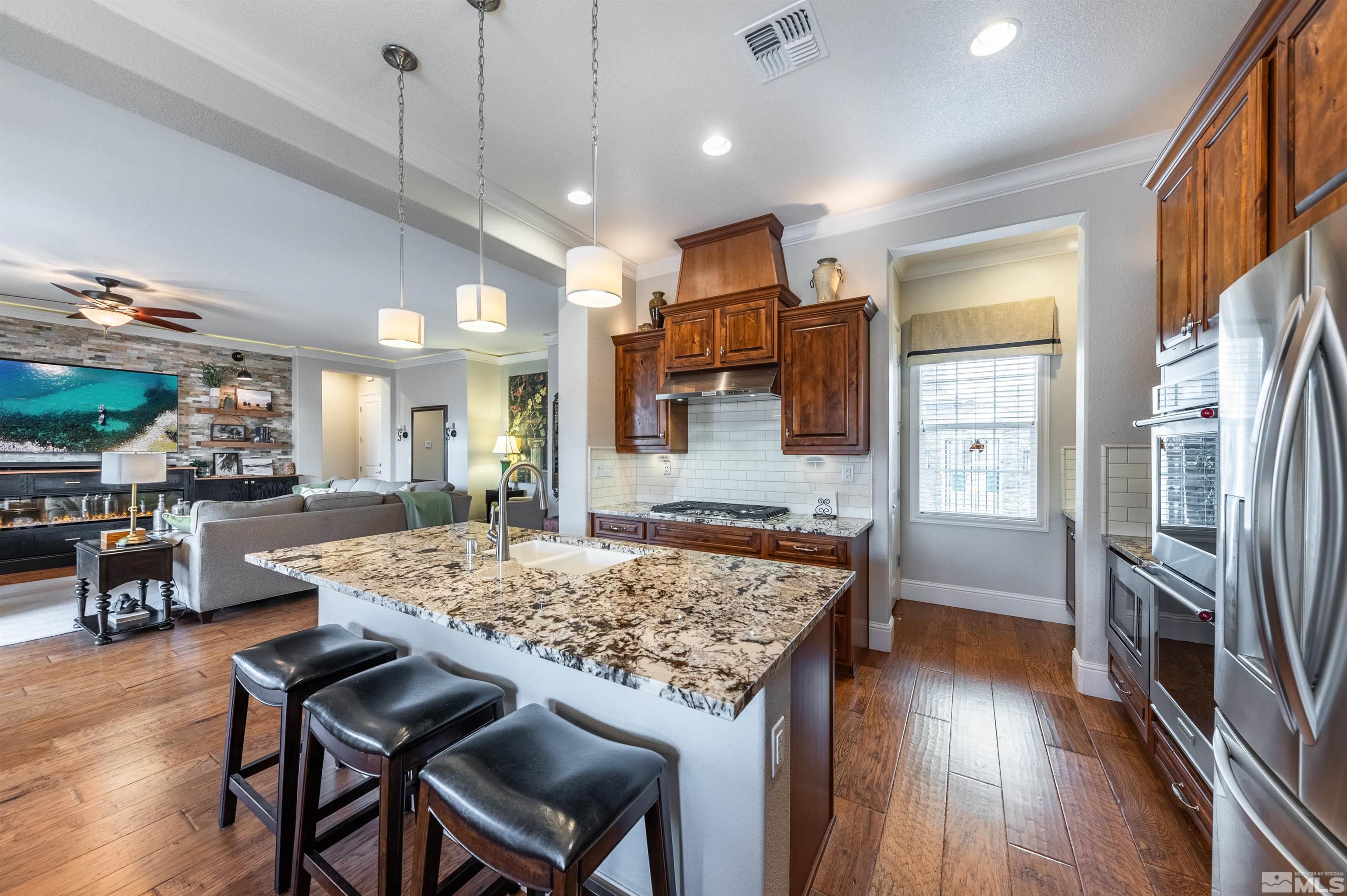 9805 Shadowless Trail Reno, NV 89521 - Photo 9 of 33 a kitchen with stainless steel appliances granite countertop table chairs and wooden floor
