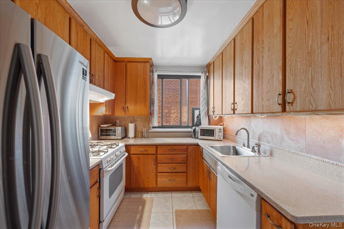 4315 Webster Avenue, Unit 5E Bronx, NY 10470 - Photo 18 of 21 a kitchen with a sink a counter top space stainless steel appliances cabinets and a large window