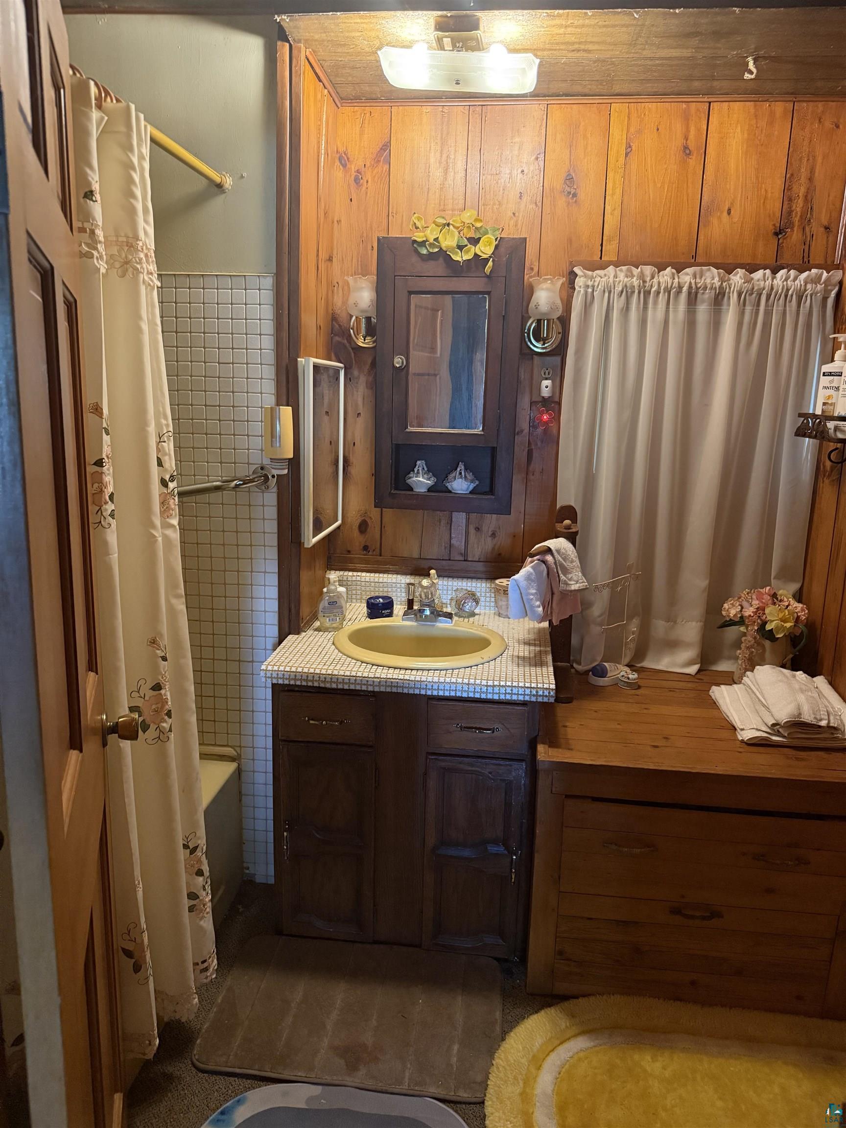 69175 East Long Lake Road Iron River, WI 54847 - Photo 14 of 47 Full bathroom featuring vanity, shower / bath combo, and wooden walls