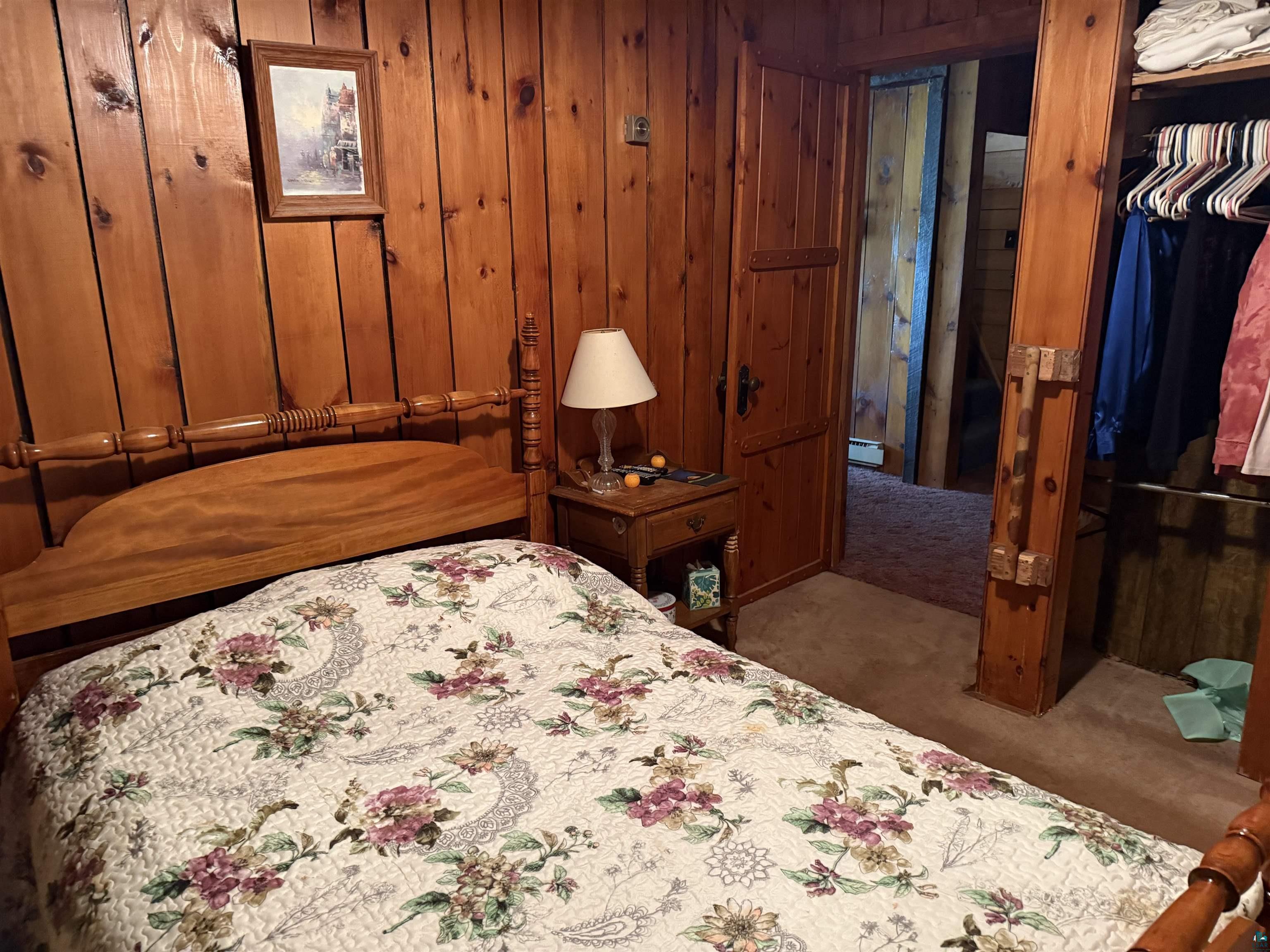 69175 East Long Lake Road Iron River, WI 54847 - Photo 21 of 47 Carpeted bedroom featuring wooden walls