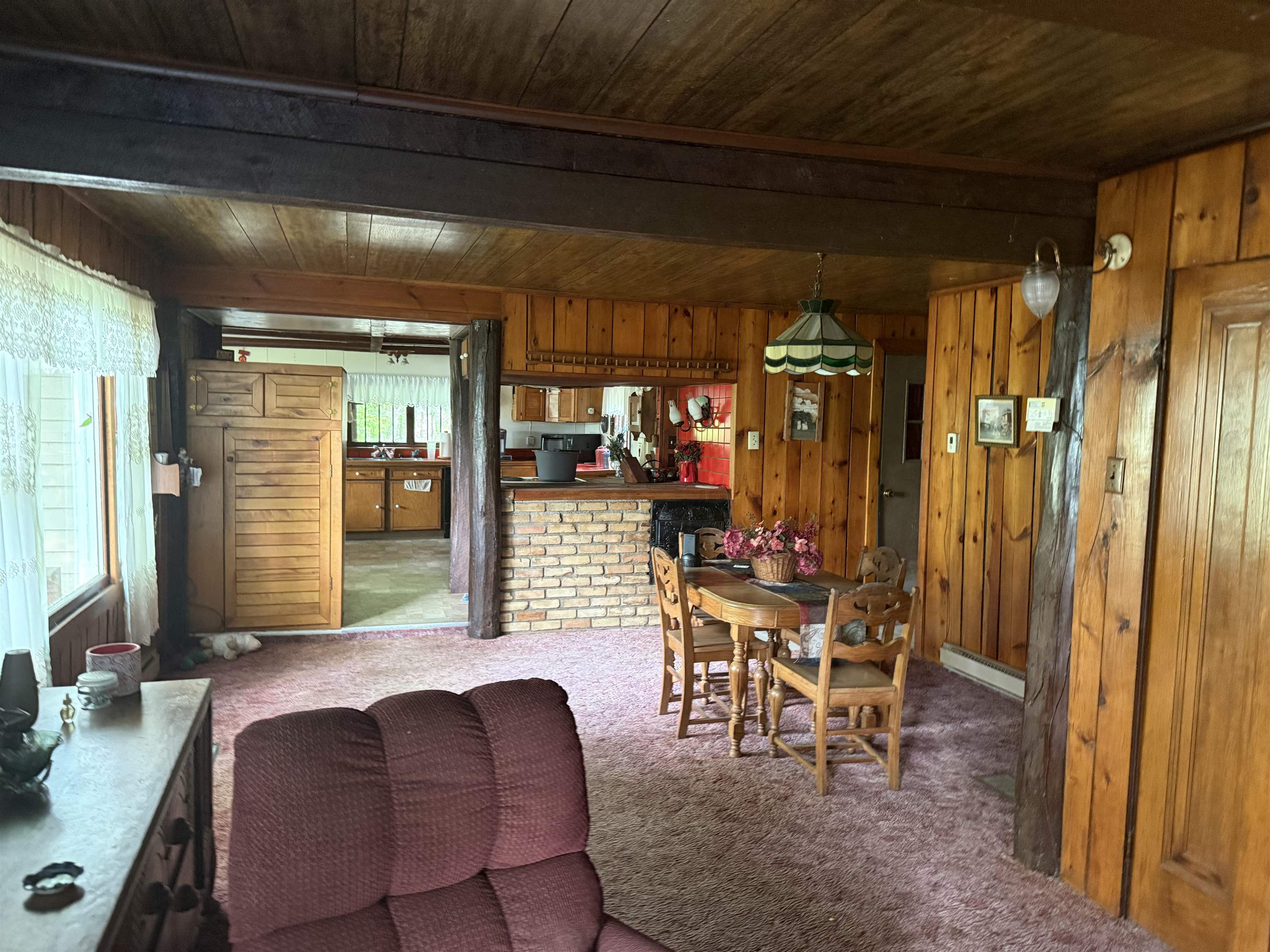 69175 East Long Lake Road Iron River, WI 54847 - Photo 6 of 47 Dining room featuring wooden ceiling with exposed beams, wooden walls, carpet floors, and a baseboard radiator