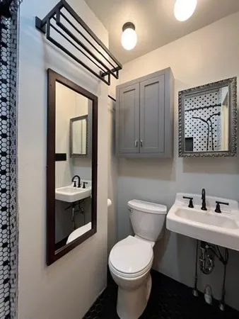 a bathroom with a toilet sink and mirror