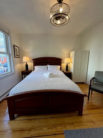 a bedroom with a bed window and a table