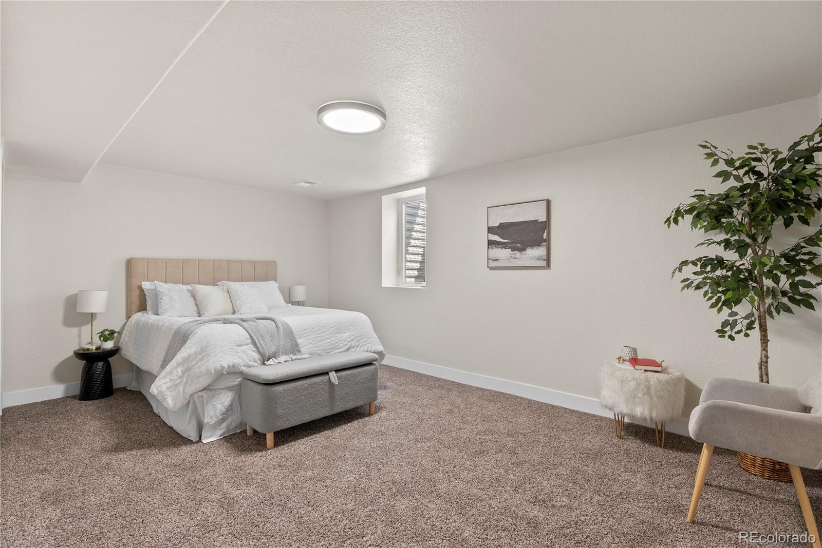 7961 Granada Road Denver, CO 80221 - Photo 18 of 31 a spacious bedroom with a bed and a chair