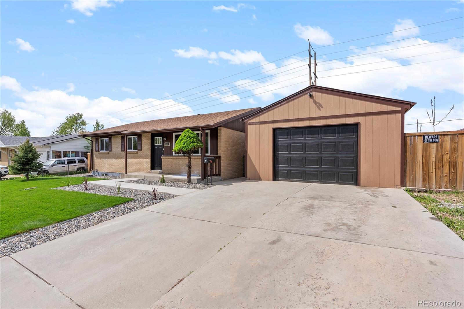 7961 Granada Road Denver, CO 80221 - Photo 3 of 31 a front view of a house with a yard and garage