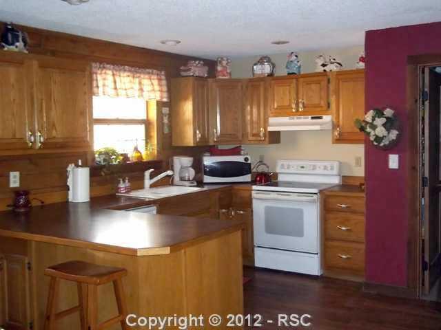 19325 Spring Valley Road Monument, CO 80132 - Photo 12 of 16 GOURMET KITCHEN FEATURING PLENTY OF COUNTER SPACE, HARDWOOD FLOORS AND NEWER APPLIANCES