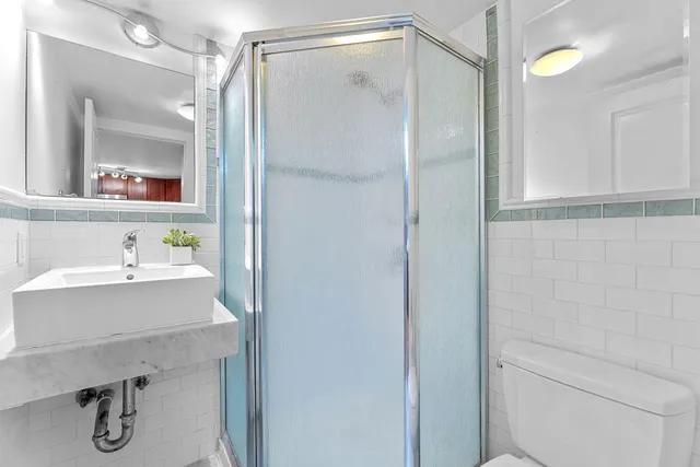 a bathroom with a shower sink vanity and mirror