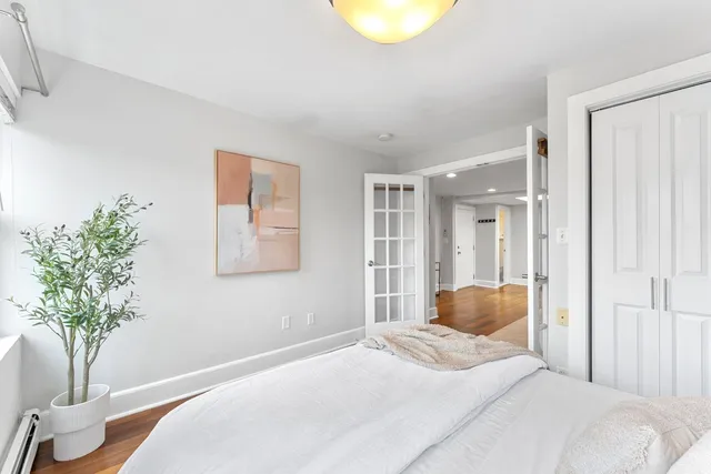 a bedroom with a large bed and a potted plant