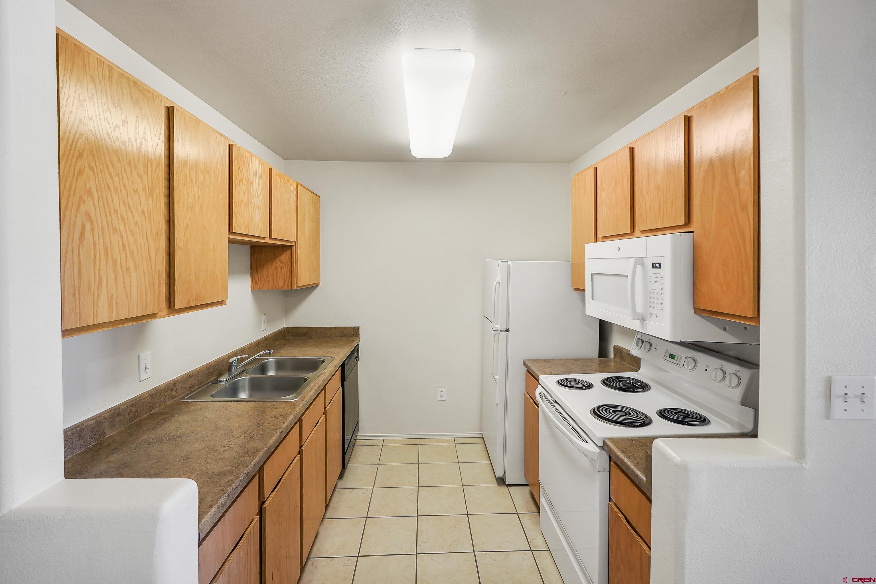 1100 Goeglein Gulch Road, Unit 155 Durango, CO 81301 - Photo 8 of 15 a kitchen with a stove a sink and a refrigerator