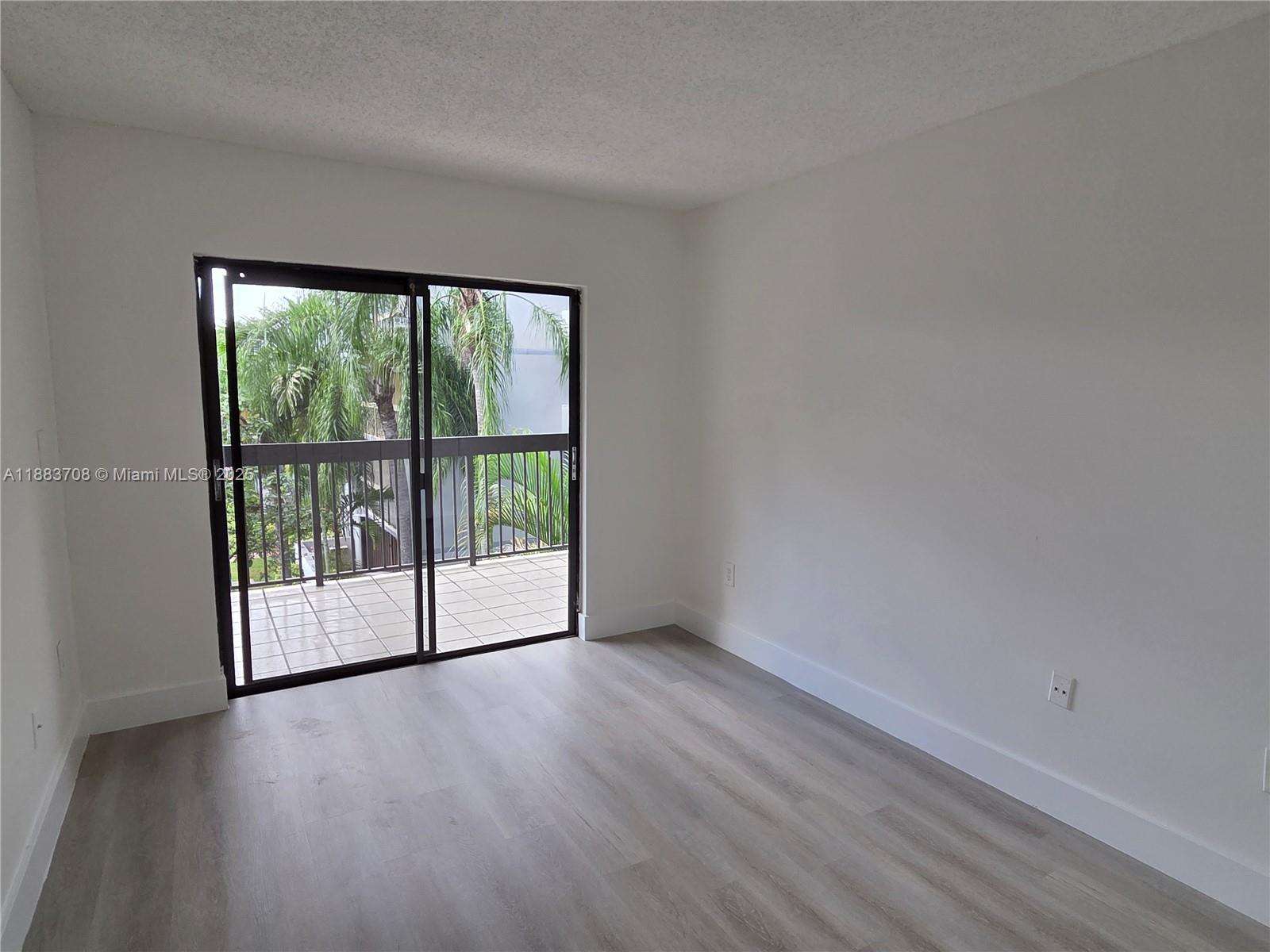 8888 Southwest 131st Court, Unit 308 Miami, FL 33186 - Photo 16 of 25 an empty room with wooden floor and windows