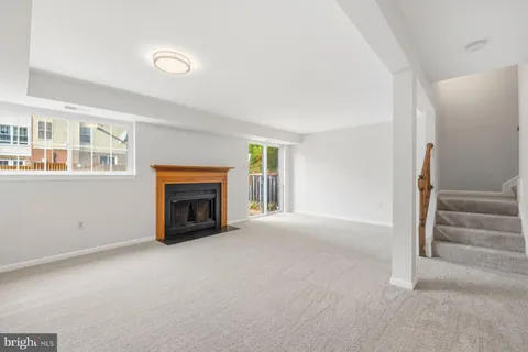 a view of an empty room with fireplace and stairs