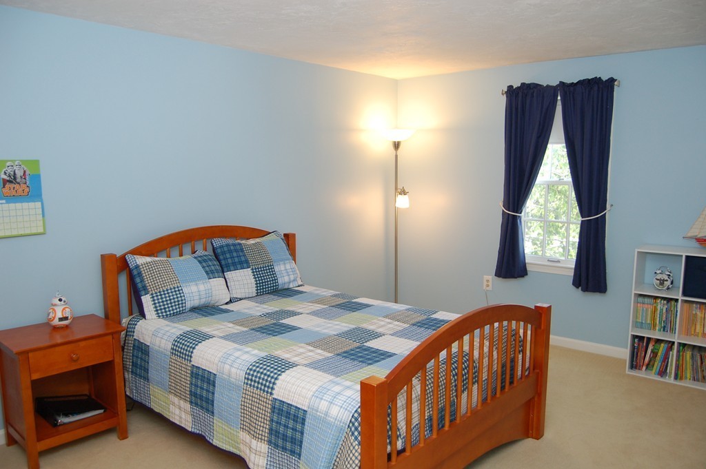 6 Schofield Road Hopkinton, MA 01748 - Photo 16 of 30 a bedroom with a bed and a book shelf