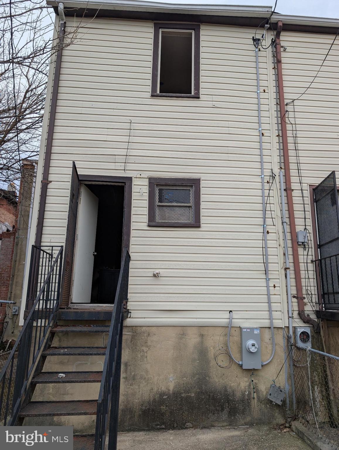 1818 Hope Street Baltimore, MD 21202 - Photo 2 of 5 a view of a house with stairs and a tree